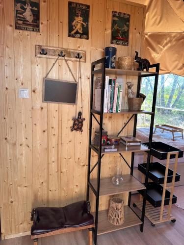 a room with a wooden wall with a book shelf at Heaven Reset Spa Luksusowy Glamping Jacuzzi w Naturze Blisko Warszawy in Korczew