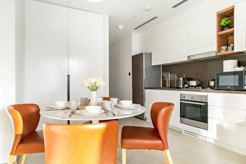 a dining room with a table and chairs in a kitchen at Panoramic Marina 1BR City Skyline Views with Balcony, Pool & Gym Access in Dubai