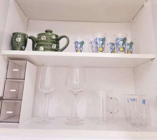 a shelf with glasses and a tea pot and vases at 스테이블홈 수서역 1분 in Seoul