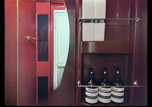 a group of wine bottles on a shelf in front of a mirror at 스테이블홈 수서역 1분 in Seoul