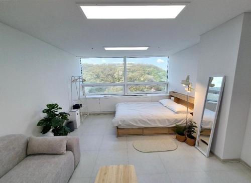a bedroom with a bed and a large window at 스테이블홈 수서역 1분 in Seoul
