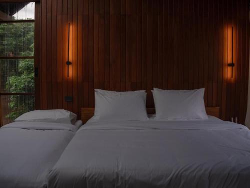 a bedroom with two beds with white sheets and a window at Ruedufon- Private Nature Retreat in Chiang Dao in Ban Tham