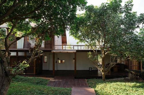 a building with trees in front of it at Ruedufon- Private Nature Retreat in Chiang Dao in Ban Tham