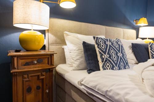 a bed with a yellow lamp on a night stand at Der Schlosswirt zu Anif - Biedermeierhotel und Restaurant in Anif