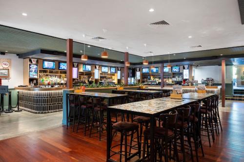 a bar with tables and chairs in a restaurant at Quality Hotel Bayswater in Perth