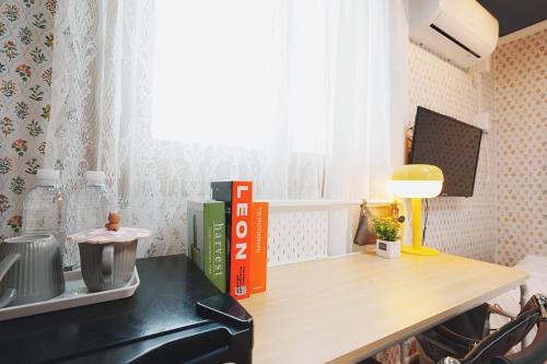 una mesa con un libro y una lámpara en un escritorio en 레토하우스, en Incheon
