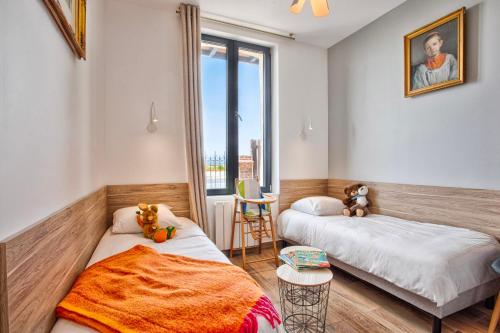 a bedroom with two beds and a window at VILLA 139 LA VAGUE - FRONT DE MER - appartement contemporain et terrasse sur cour - 2 à 6 personnes - Rez-de-chaussée in Houlgate