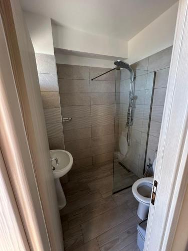 a bathroom with a toilet and a glass shower at LA PLAYA - Seaside Guest Room in Durrës