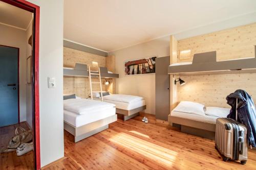a bedroom with two bunk beds and a staircase at JUFA Hotel Maria Lankowitz in Maria Lankowitz