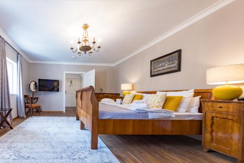 a bedroom with a wooden bed and a chandelier at Der Schlosswirt zu Anif - Biedermeierhotel und Restaurant in Anif