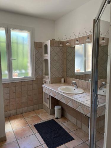 une salle de bain avec un lavabo et un miroir dans l'établissement Le MOTU, à Cuers