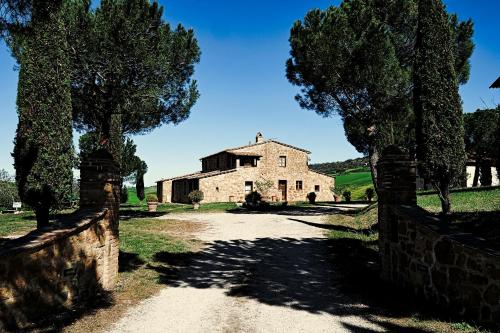 an old stone house with a road in front of it at Agriturismo Il Casalino in Pienza