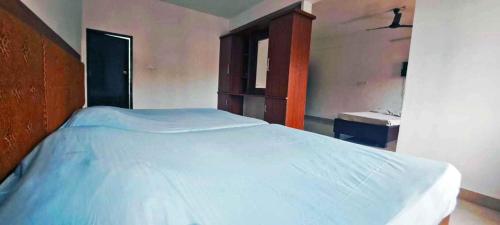 a bedroom with a large bed with a wooden headboard at Elite Residency in Taliparamba