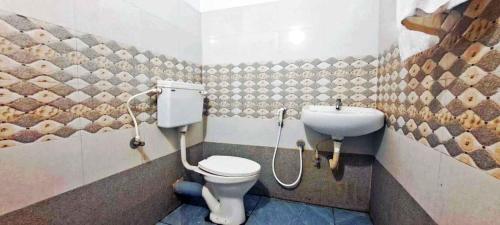 a bathroom with a toilet and a sink at Elite Residency in Taliparamba