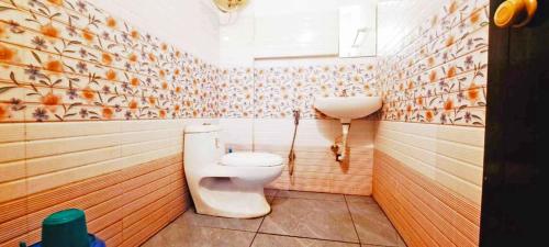 a bathroom with a toilet and a sink at Elite Residency in Taliparamba