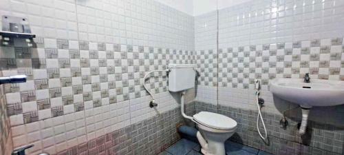 a bathroom with a toilet and a sink at Elite Residency in Taliparamba