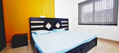 a bedroom with a bed in a room with a window at Elite Residency in Taliparamba
