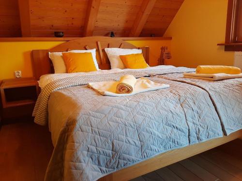 a bed with two towels and a hat on it at Eco House Mozirje in Mozirje