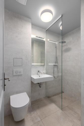 a bathroom with a toilet and a sink and a shower at Roze Park Rooms in Liepāja