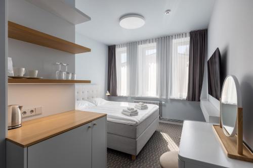 a room with a bed and a couch in a room at Roze Park Rooms in Liepāja