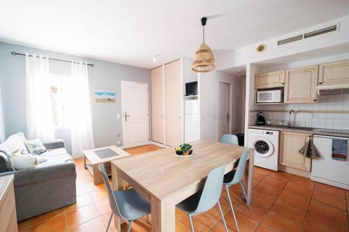 a kitchen and living room with a wooden table and chairs at Provençal Villa in Secure Area with Swimming Pool in Fayence