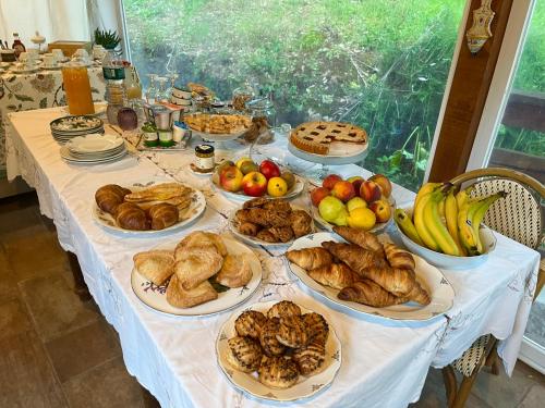 a table with many plates of bread and fruit on it at B&B La Fucinaia Pet Friendly Adults only in Campiglia Marittima