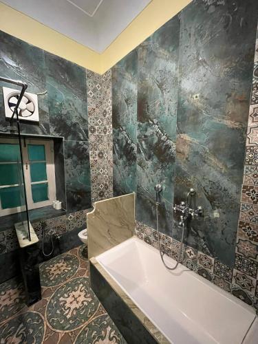 a bathroom with a bath tub and a sink at Hotel Bissau Palace in Jaipur
