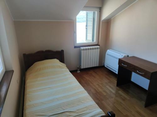 a small bedroom with a bed and a desk at Holiday Home Ploski in Herceg-Novi