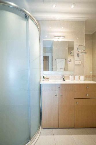a bathroom with a shower and a sink and a mirror at Avientu By Silastur in Gijón