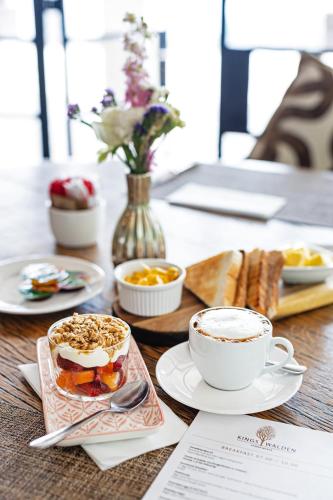 Una mesa con un plato de comida y una taza de café. en Kings Walden Garden Manor, en Tzaneen