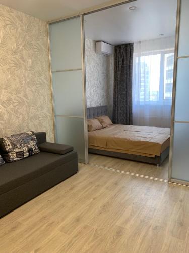 a bedroom with a bed and a couch and a mirror at 51 жемчужина Аркадія in Odesa