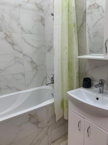 a bathroom with a white tub and a sink at 51 жемчужина Аркадія in Odesa