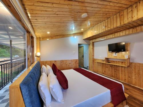 a bedroom with a large bed and a tv at The Kufri House in Fagu