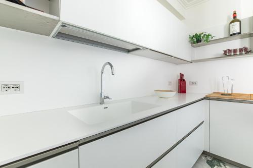 een keuken met witte kasten en een spoelbak bij Luxury Marble House in Pietrasanta