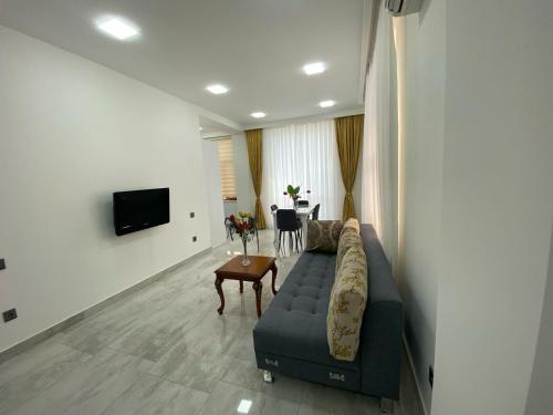 a living room with a couch and a table at Style Home Buzovna in Baku