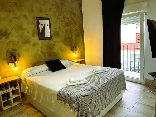 a bedroom with a bed with two towels on it at Apartamentos Ohana Mérida - Centro - Parking Gratis - Todo a Pie - Pet Friendly - Espacios Exclusivos in Mérida