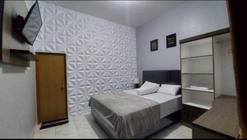 a bedroom with a bed and a tv in it at Homestay Pipa in Sukarami