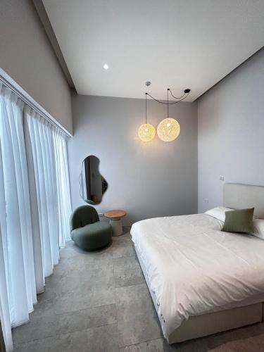 1 dormitorio con 1 cama, 1 silla y TV en Hsia Mu Le, en Zhongpu