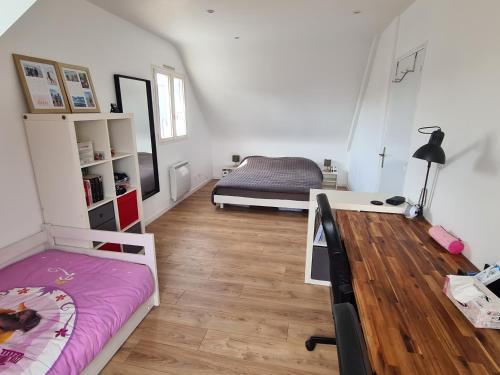 une chambre avec deux lits et un bureau dans l'établissement maison bord de mer, à Plérin