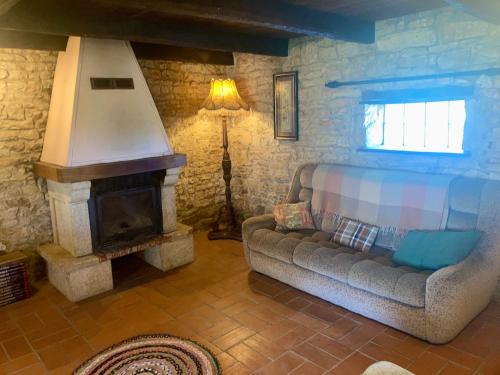 un salon avec un canapé et une cheminée dans l'établissement The Cowshed, à Chassiecq