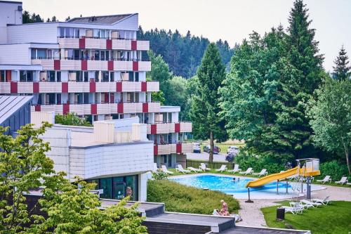 a resort with a slide and a swimming pool at Englmar Apartments with free WELLNESS and FITNESS in Sankt Englmar