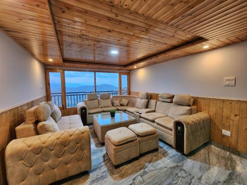 a living room with couches and a table at The Kufri House in Fagu