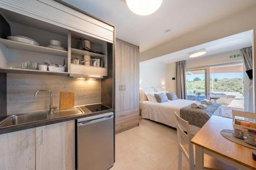 a kitchen with a sink and a bedroom with a bed at Casa Di Sebastian in Gaios