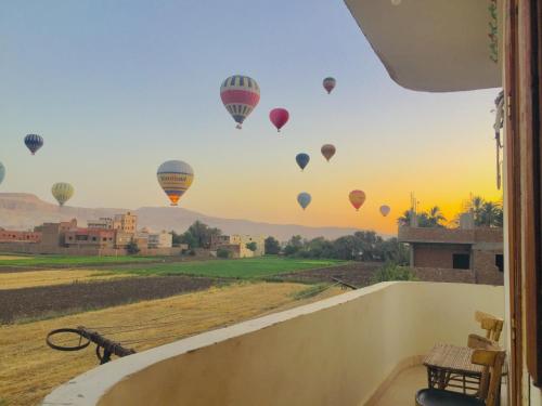 a group of hot air balloons flying in the sky at sun smile guest house᭄ꦿ in Luxor