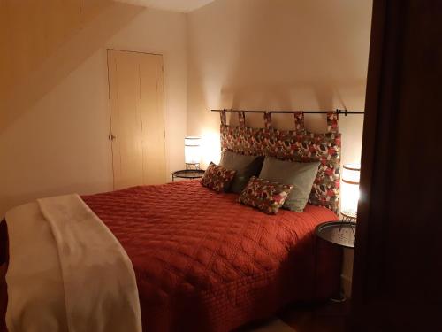 a bedroom with a red bed with two lamps at La Maison de Claire in Flavigny-sur-Ozerain
