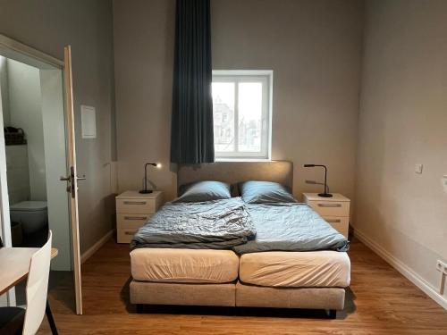 a bedroom with a bed with blue pillows and a window at Wohnquartier Mühlenhof in Neuenkirchen-Vörden in Neuenkirchen-Vörden