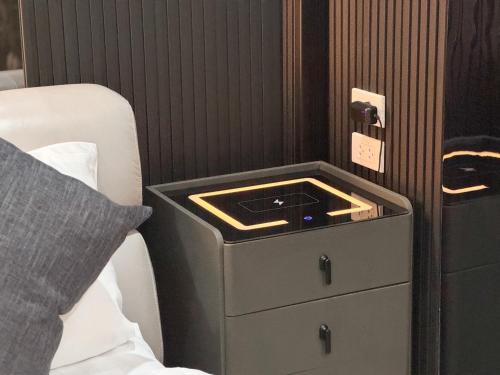 a bedroom with a night stand next to a bed at Delta9 Phrakanong 3 mins BTS Phrakanong in Bangkok