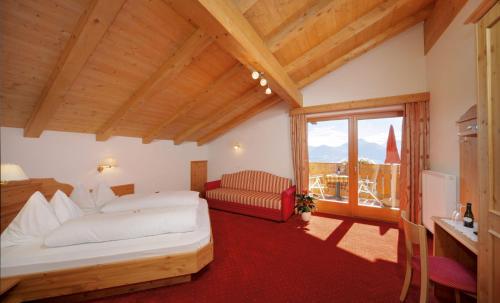 a bedroom with a bed and a large window at Hotel Rastlhof in Schenna