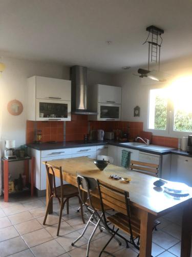 Il comprend une cuisine avec une table et des chaises en bois. dans l'établissement Maison BELLOU à LA FRANQUI, à La Franqui-Plage