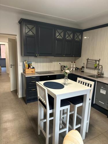 a kitchen with black cabinets and a white table and chairs at Mysig lägenhet Malmö Centralt in Malmö